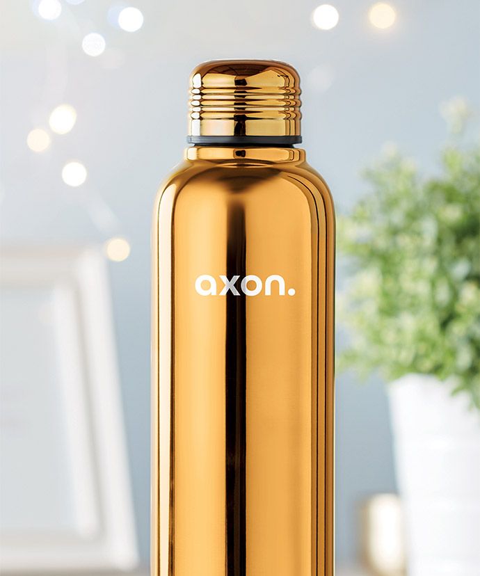 Goldfarbene Thermoskanne mit Aufdruck mit Pflanze im Hintergrund. Werbeartikel für den Winter.