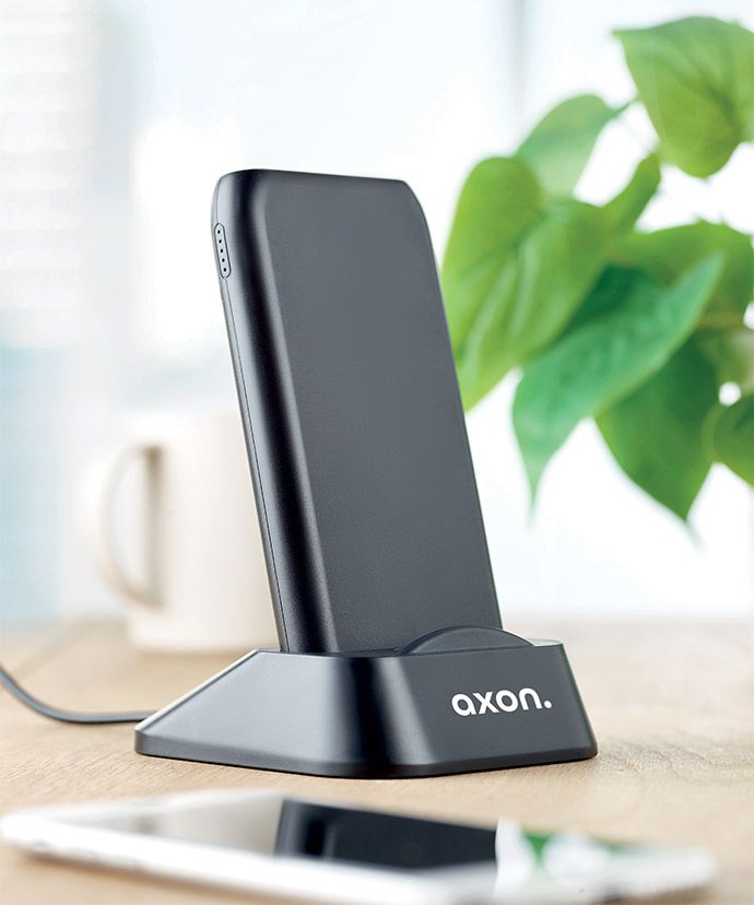 Schwarzes kabelloses Ladegerät mit Aufdruck auf einem Tisch. Werbeartikel für das Büro.